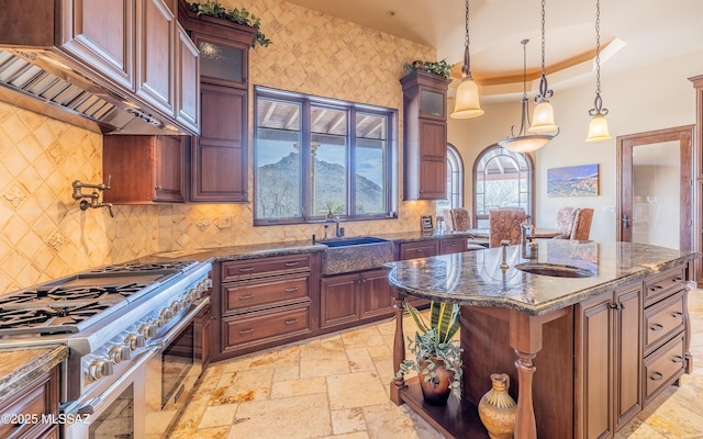 kitchen with stone tile flooring, double oven range, glass insert cabinets, and a sink