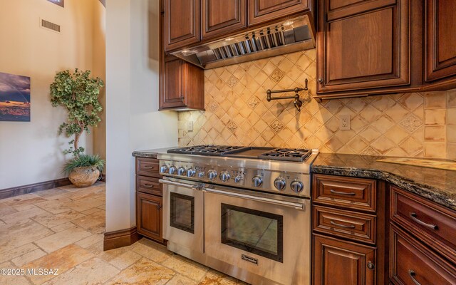 kitchen with visible vents, baseboards, double oven range, stone tile flooring, and custom exhaust hood