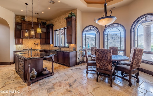 dining space featuring visible vents, baseboards, arched walkways, and stone tile flooring