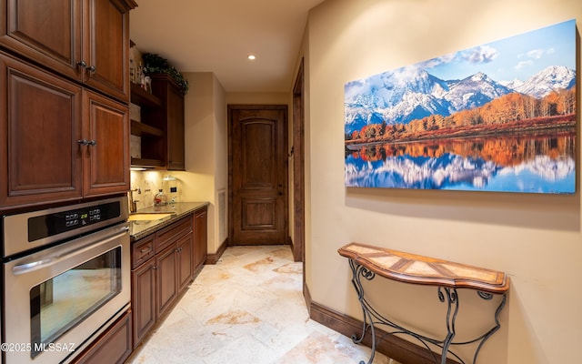 kitchen with stainless steel oven, a mountain view, baseboards, and recessed lighting