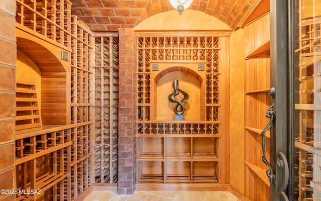 wine cellar featuring brick ceiling and vaulted ceiling