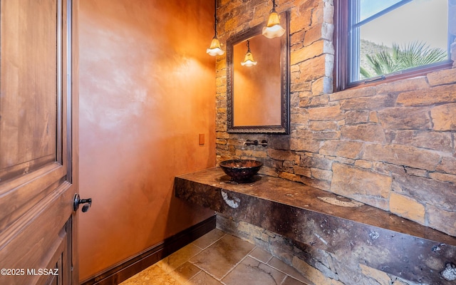 bathroom featuring baseboards and stone tile flooring