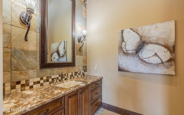 bathroom with tasteful backsplash, vanity, and baseboards