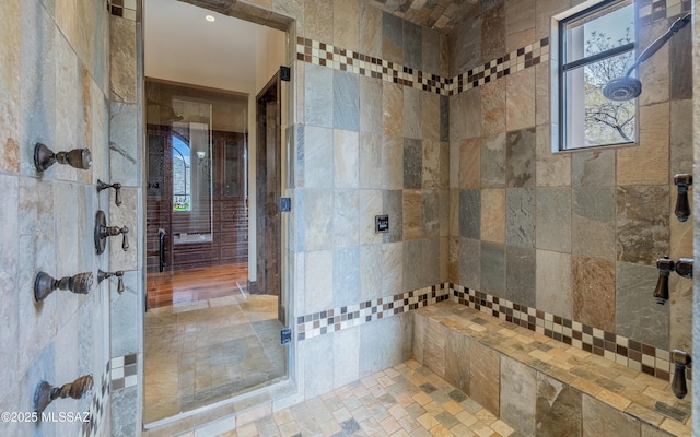 full bath featuring a tile shower and plenty of natural light