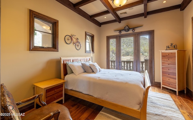 bedroom with visible vents, baseboards, beamed ceiling, wood finished floors, and coffered ceiling