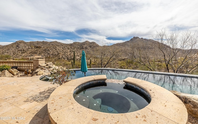 view of pool featuring a mountain view and an in ground hot tub