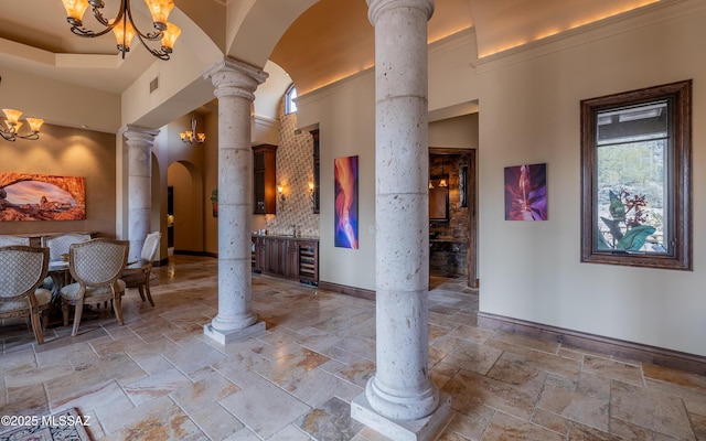 interior space featuring visible vents, stone tile floors, wine cooler, arched walkways, and ornate columns