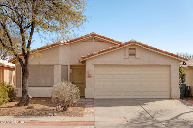 view of front facade with a garage, concrete driveway, a tile roof, and stucco siding