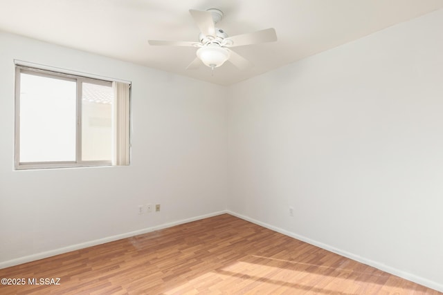 spare room with light wood-type flooring, ceiling fan, and baseboards