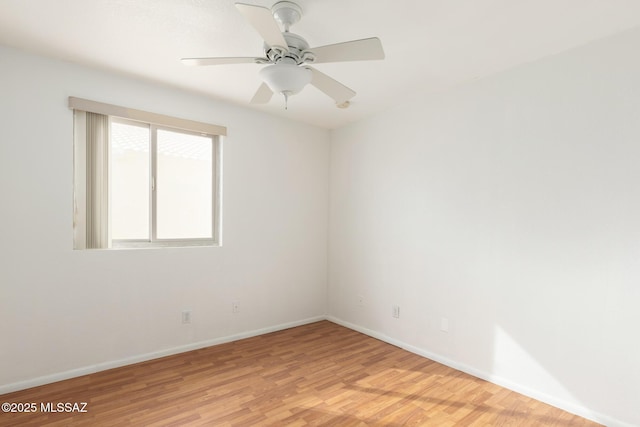 spare room featuring light wood-style flooring, baseboards, and ceiling fan