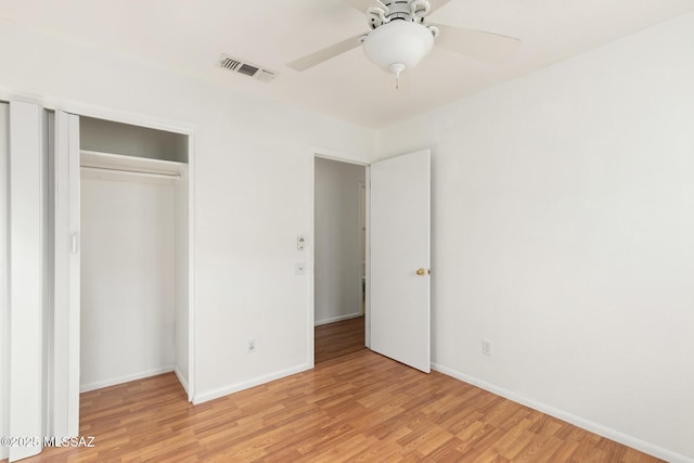 unfurnished bedroom with baseboards, visible vents, a ceiling fan, light wood-style floors, and a closet