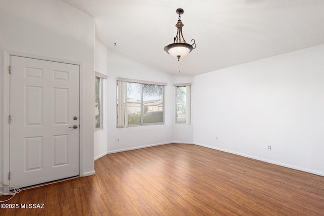 entryway featuring lofted ceiling, baseboards, and wood finished floors