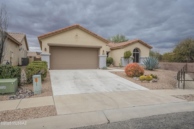 mediterranean / spanish-style house with driveway, an attached garage, a tile roof, and stucco siding