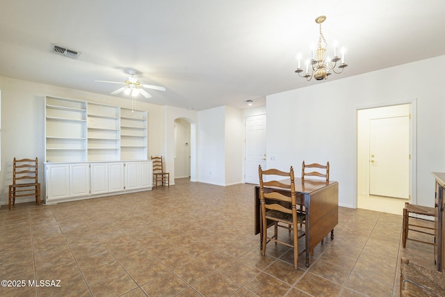 dining area with arched walkways, visible vents, baseboards, and ceiling fan with notable chandelier