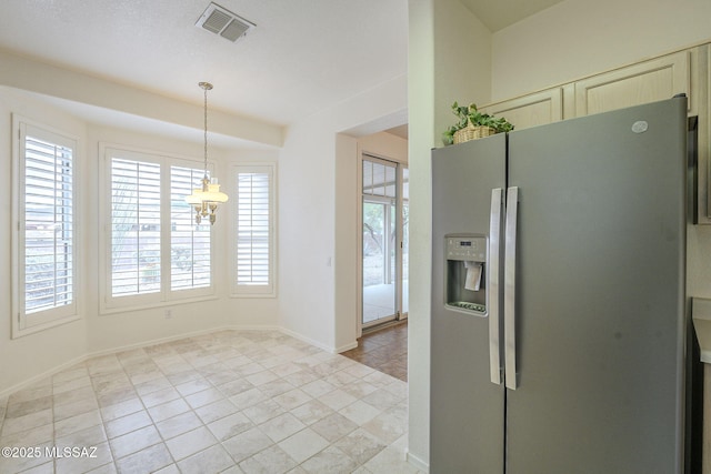 kitchen featuring cream cabinets, visible vents, baseboards, hanging light fixtures, and stainless steel fridge with ice dispenser