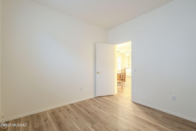 empty room featuring light wood-type flooring and baseboards