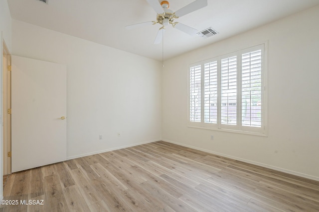 empty room featuring light wood-style flooring, visible vents, ceiling fan, and baseboards