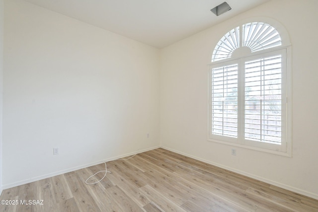 unfurnished room with light wood finished floors and baseboards