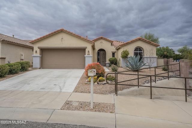 mediterranean / spanish home featuring a garage, driveway, a tiled roof, and stucco siding