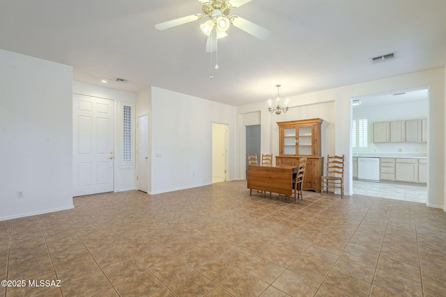 tiled spare room with baseboards, visible vents, and ceiling fan with notable chandelier