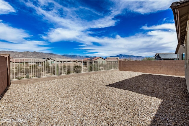 view of yard with a fenced backyard and a mountain view