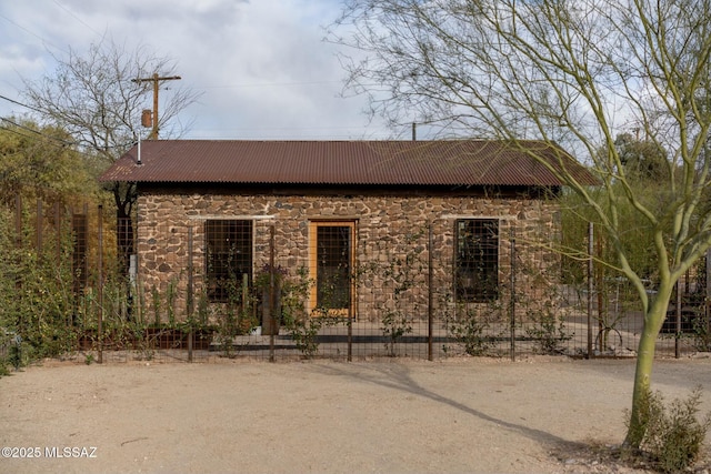 view of property exterior with stone siding and metal roof