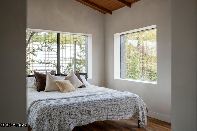 bedroom with vaulted ceiling with beams, wood ceiling, baseboards, and wood finished floors