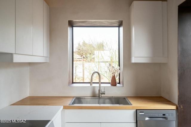 kitchen with a sink, modern cabinets, white cabinets, and stainless steel dishwasher