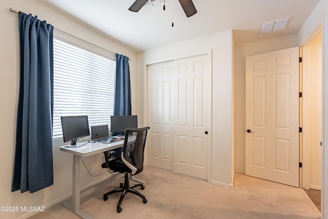 home office with visible vents, light carpet, baseboards, and ceiling fan