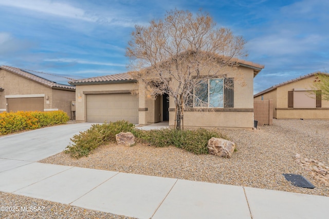 view of front of house featuring fence, a tile roof, concrete driveway, stucco siding, and a garage