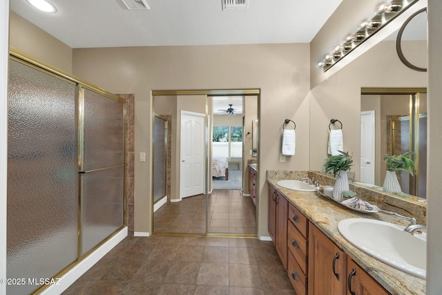 ensuite bathroom with a shower stall, connected bathroom, double vanity, and a sink