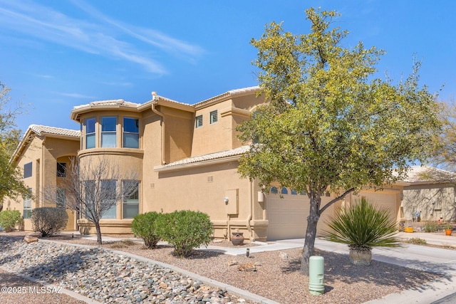 view of front of property featuring stucco siding, concrete driveway, and a tile roof