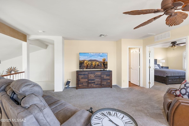 carpeted living room featuring visible vents, baseboards, and a ceiling fan