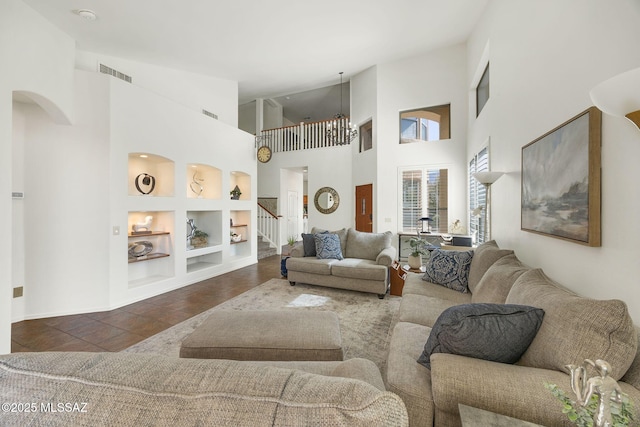 living area with stairway, built in features, visible vents, arched walkways, and tile patterned floors