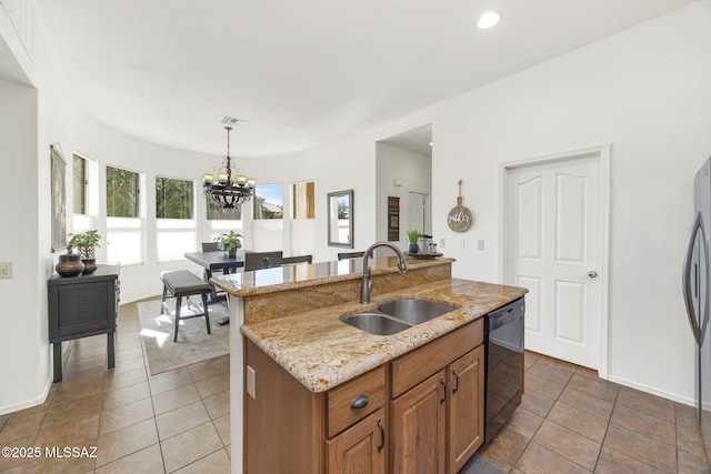 kitchen with brown cabinetry, light stone countertops, a sink, black dishwasher, and pendant lighting