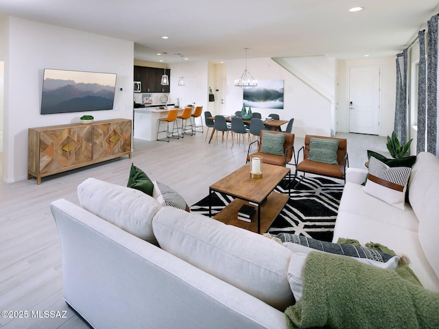 living area with a chandelier, recessed lighting, and light wood-type flooring