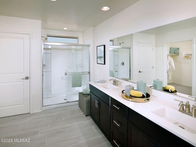 full bath featuring double vanity, recessed lighting, a stall shower, and a sink