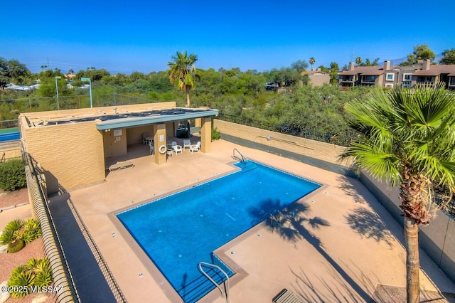 pool with fence and a patio