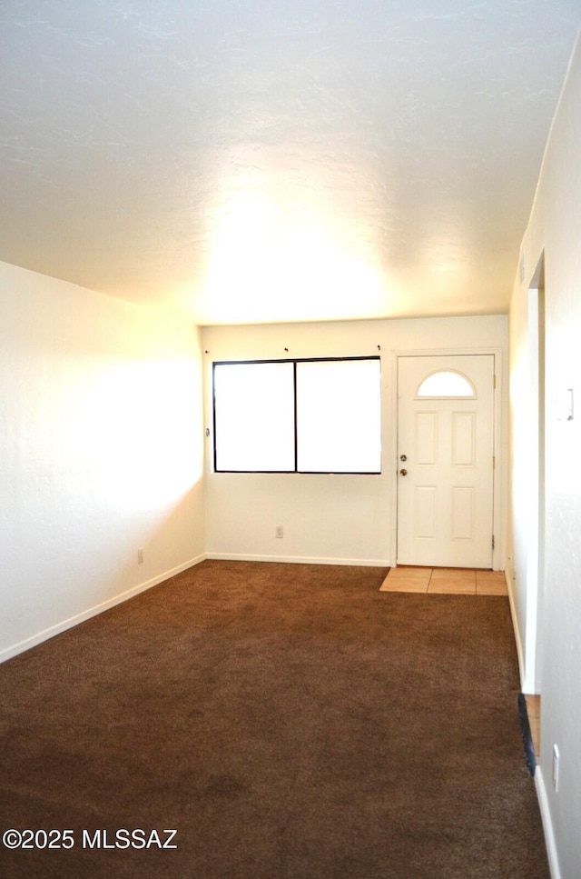 carpeted spare room with baseboards