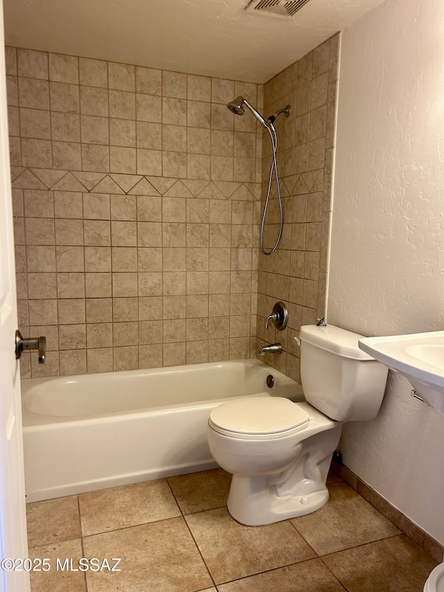 full bathroom with baseboards, shower / bath combination, tile patterned floors, toilet, and a textured wall