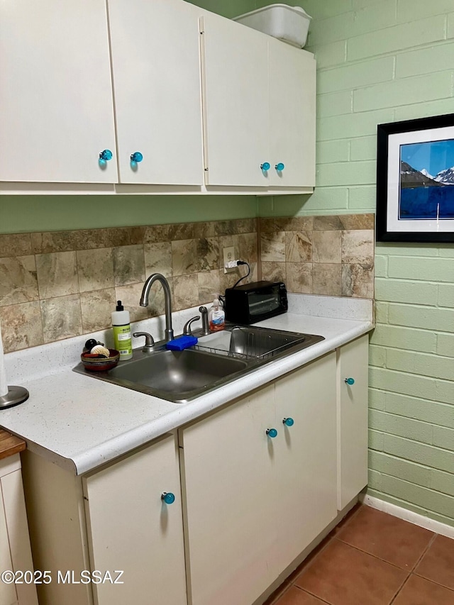 kitchen with light countertops, a sink, and white cabinets