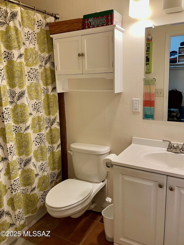 bathroom featuring a textured wall, vanity, toilet, and tile patterned floors