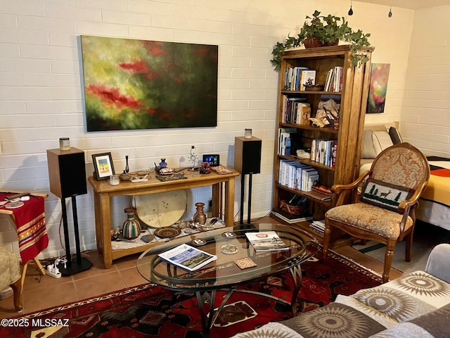 living area featuring brick wall and tile patterned flooring