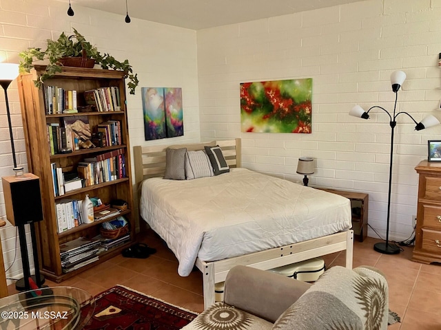 bedroom featuring brick wall and tile patterned flooring