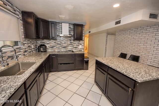 2724 N Green Pl, Nogales, AZ 85621 - kitchen with tasteful backsplash, visible vents, wall chimney range hood, a sink, and light tile patterned flooring