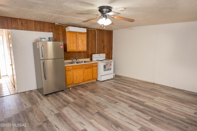 2724 N Green Pl, Nogales, AZ 85621 - kitchen with white electric stove, freestanding refrigerator, light countertops, light wood-type flooring, and a sink