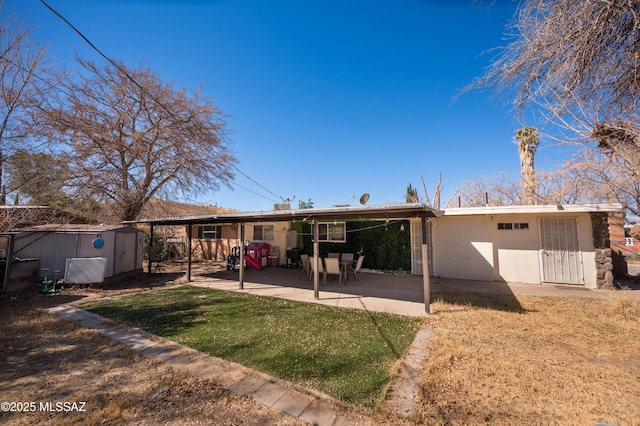 2724 N Green Pl, Nogales, AZ 85621 - rear view of house featuring a yard, stucco siding, a storage unit, a patio area, and an outdoor structure