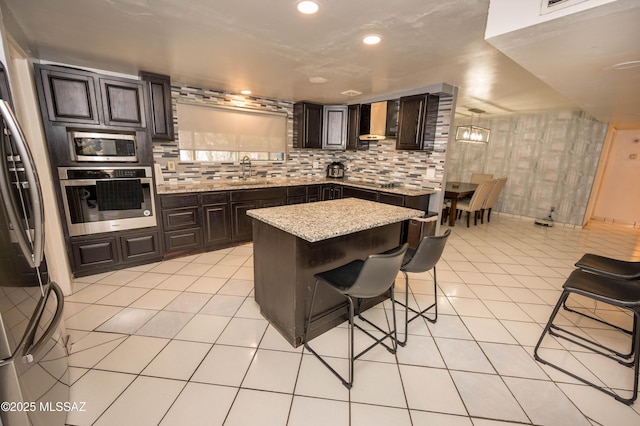 2724 N Green Pl, Nogales, AZ 85621 - kitchen featuring wall chimney exhaust hood, appliances with stainless steel finishes, light tile patterned flooring, and a sink