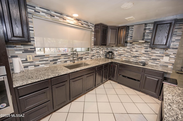 2724 N Green Pl, Nogales, AZ 85621 - kitchen with light tile patterned flooring, black electric cooktop, a sink, wall chimney range hood, and decorative backsplash