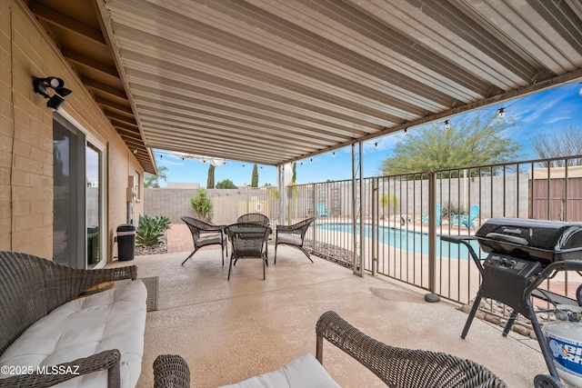 view of patio featuring a fenced in pool, outdoor dining space, a fenced backyard, and a grill